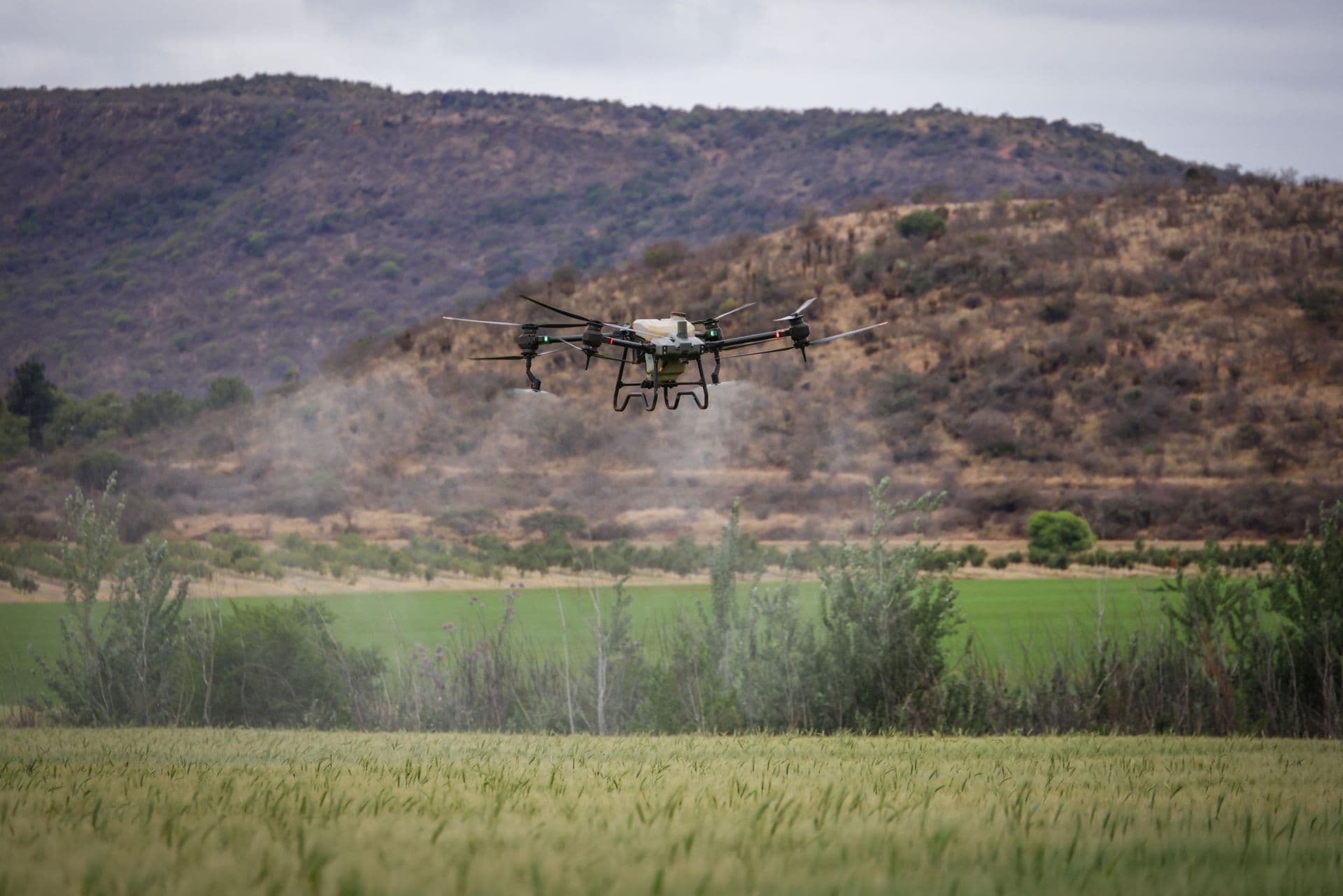 Survey drone flying over farmland with a mountain range in the distance
