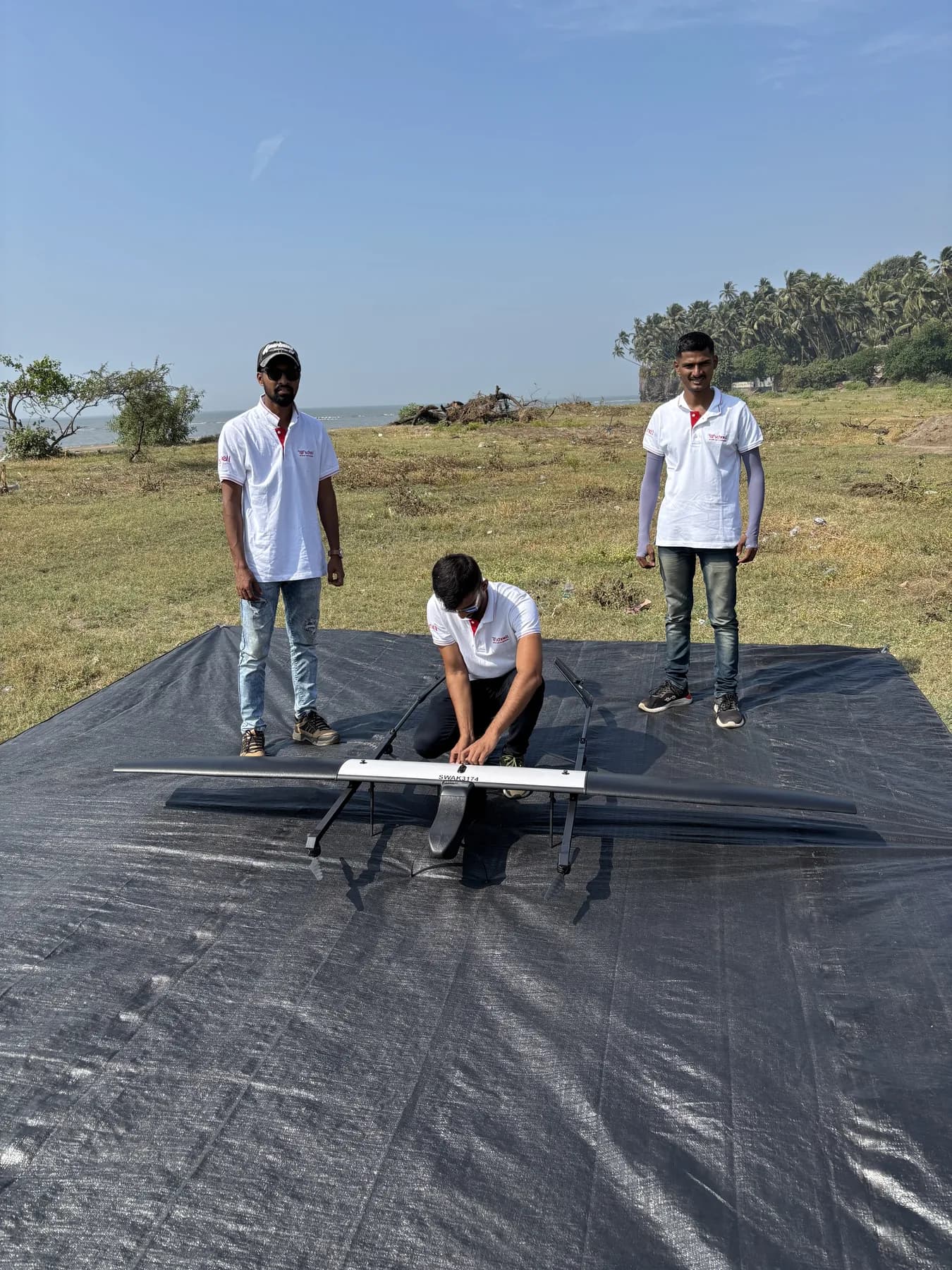 Schnell crew preparing a fixed-wing VTOL drone for launch on the coast