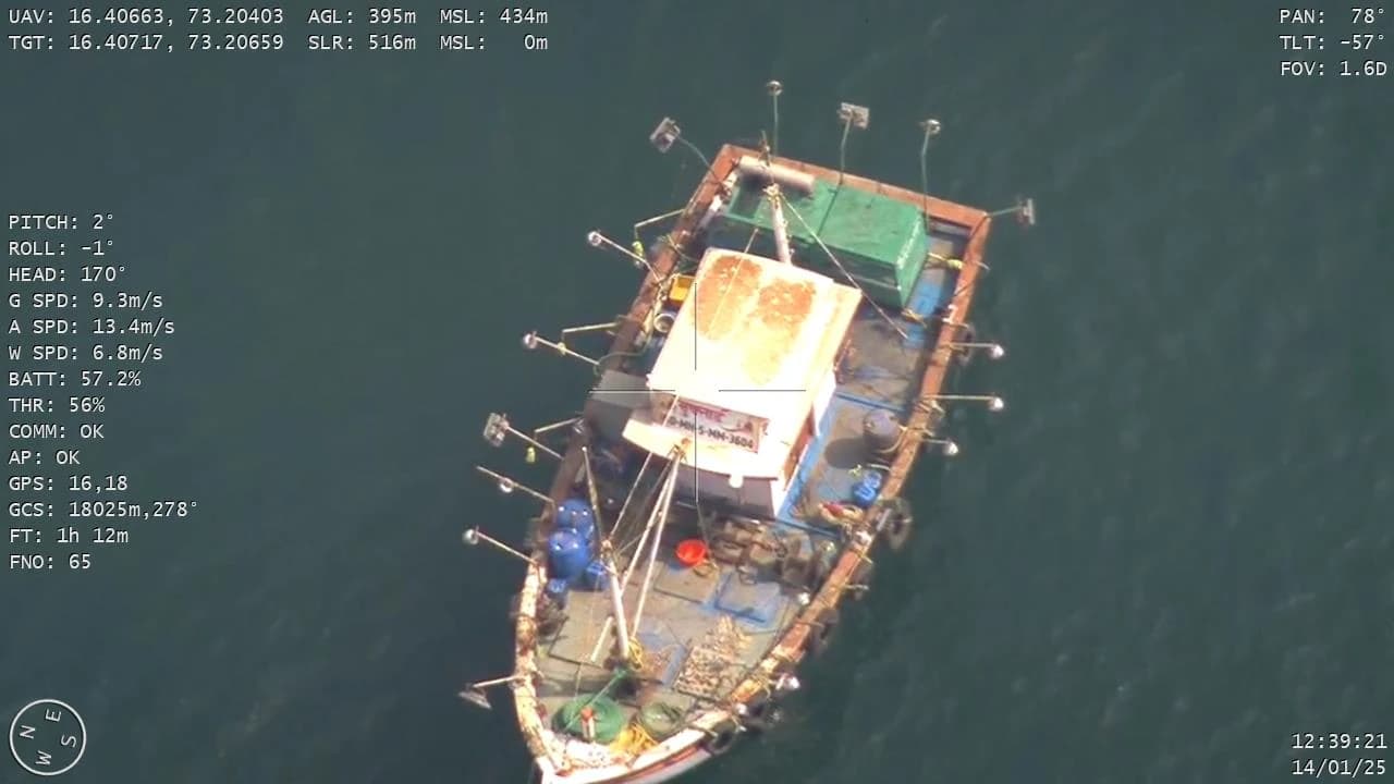 Drone downlink frame showing a fishing boat rigged with LED lights, captured during a coastal surveillance sortie