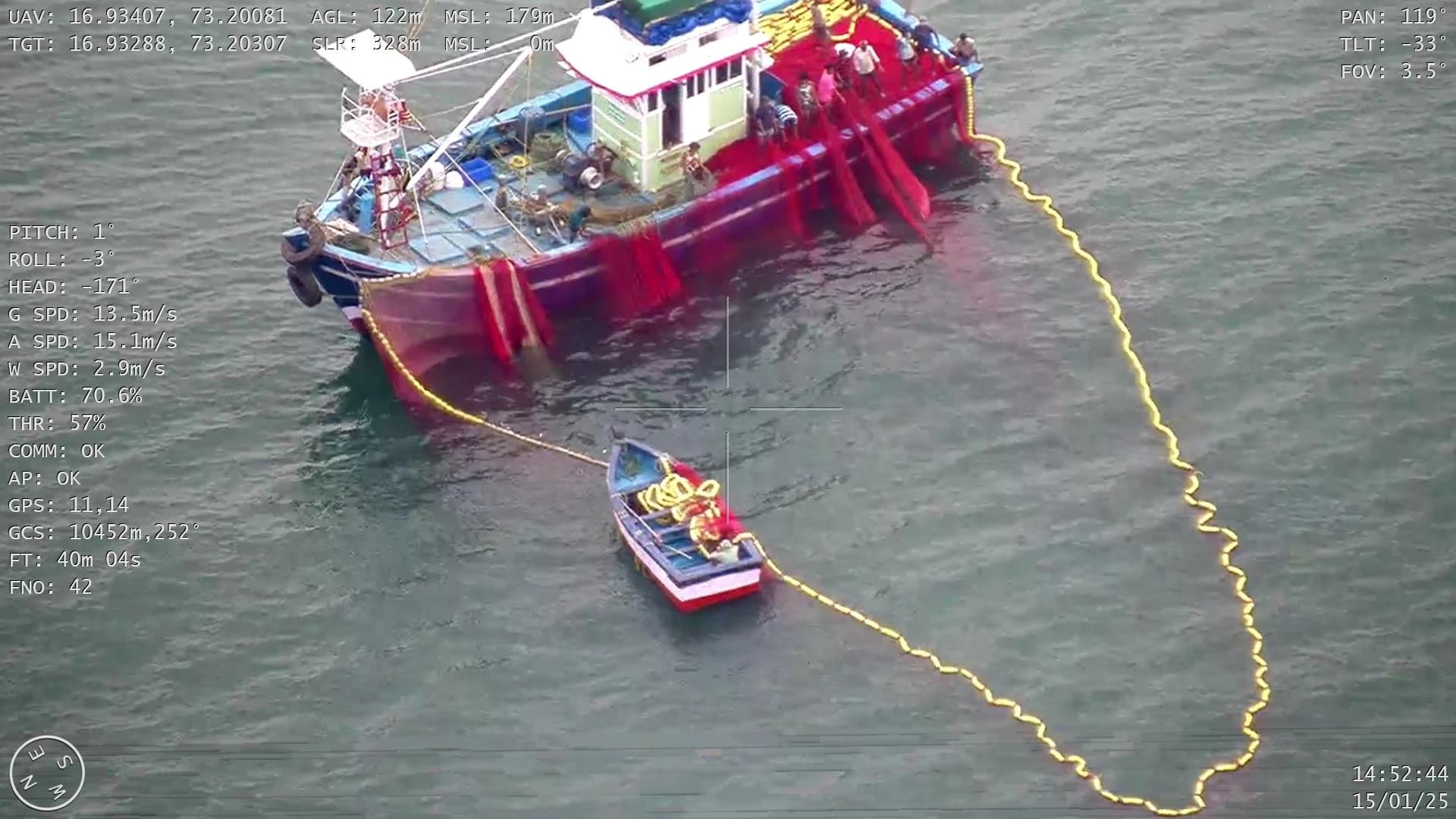 Drone downlink frame of a trawler with its net deployed alongside a smaller boat, with flight telemetry overlaid