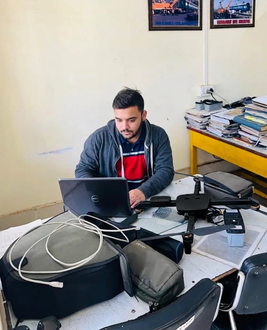Engineer running diagnostics on a laptop connected to a quadcopter