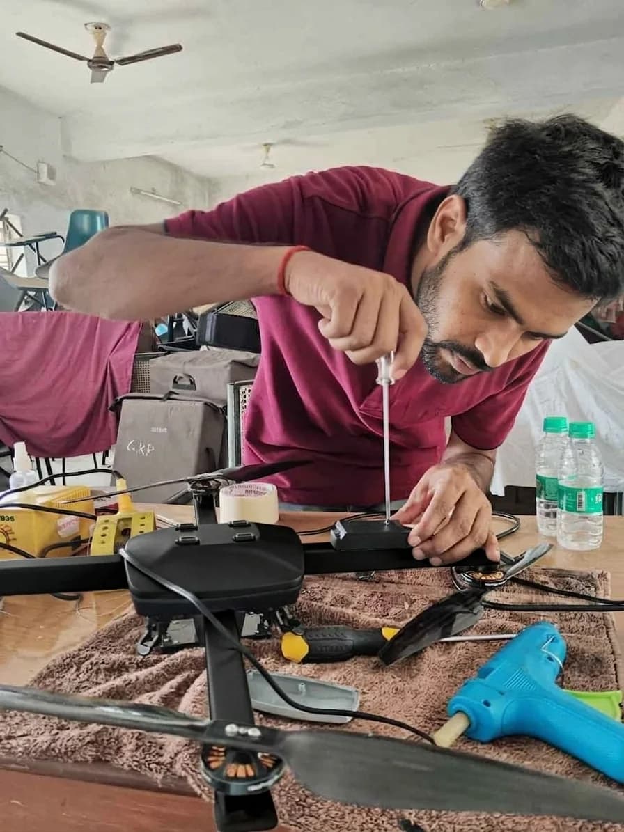 Schnell engineer tightening a screw on a drone arm at a workbench