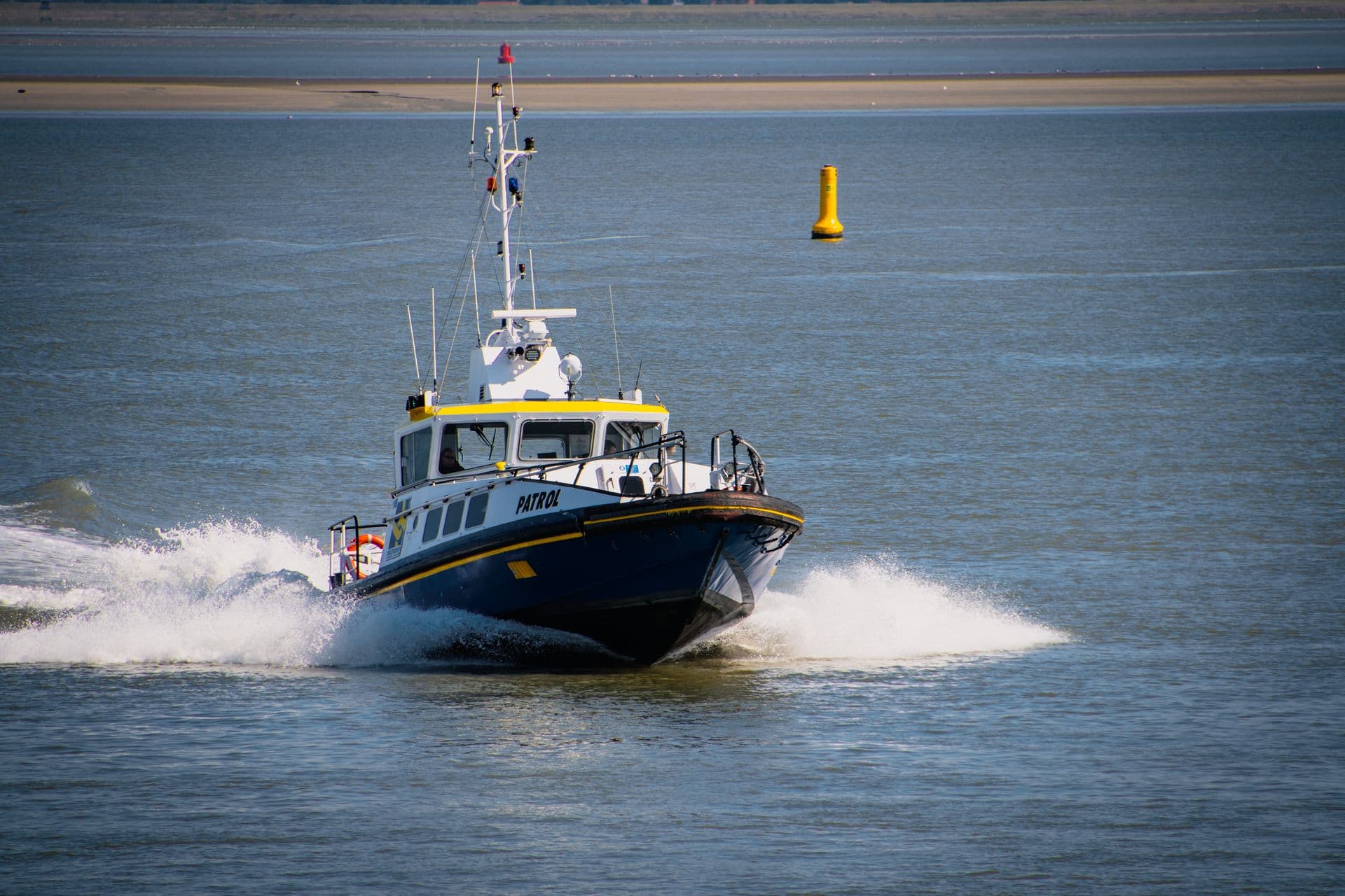 Maritime patrol vessel under drone surveillance in coastal waters