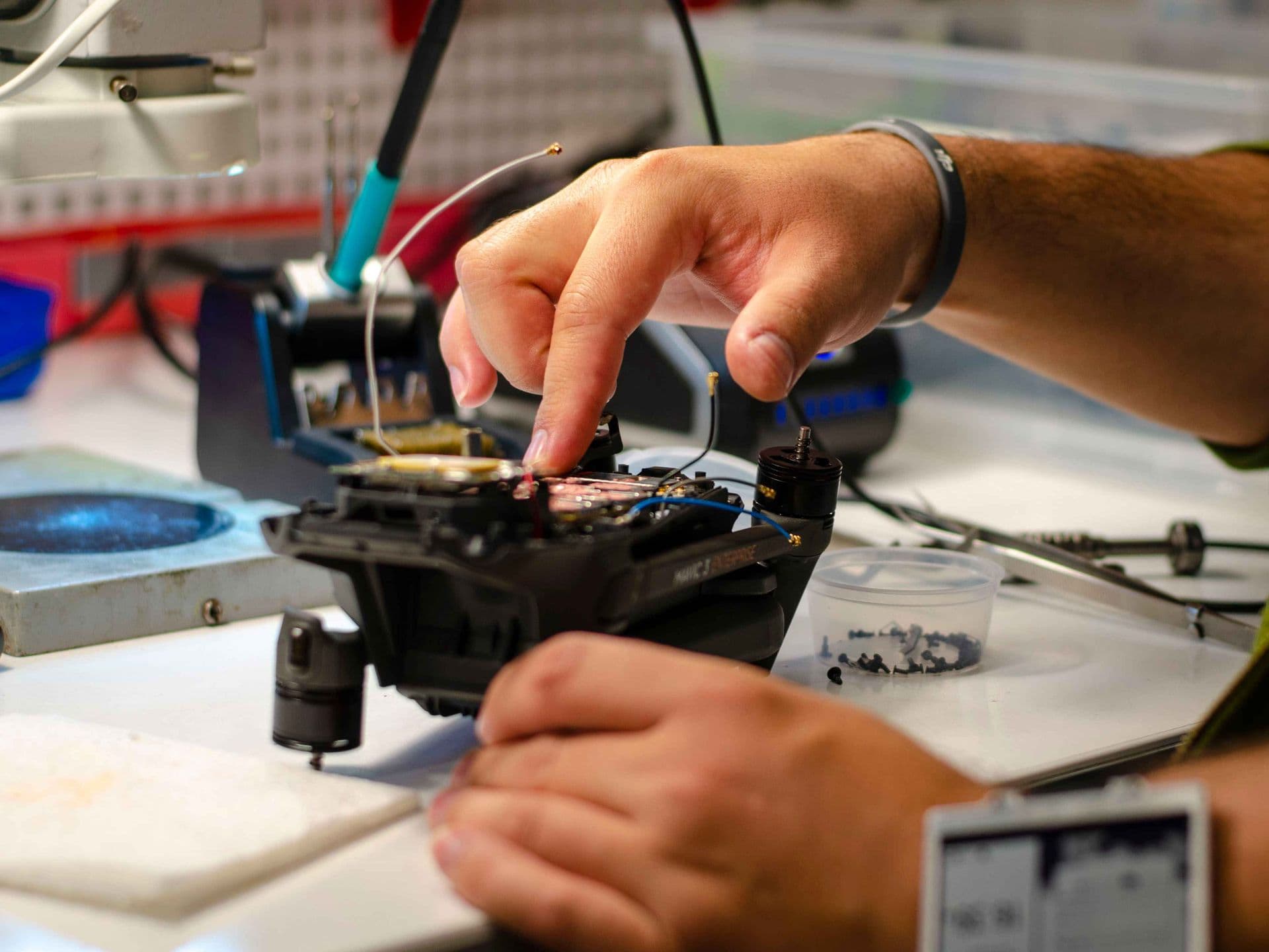 Technician repairing a drone on a workshop bench